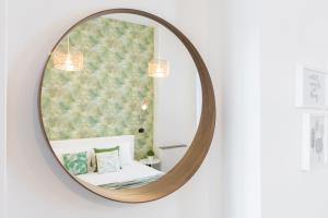 - un miroir rond suspendu au mur avec un lit dans l'établissement BMGA l Glam Industrial 3-Bed Apartment in Termini, à Rome
