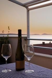 a bottle of wine and two glasses on a table at Beach Apartments Marijana in Vodice +21 photos