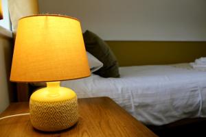 a lamp sitting on a table next to a bed at Bryn Noddfa in Morfa Nefyn