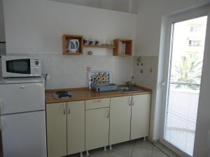 a kitchen with a white refrigerator and a sink at Apartments Anastasija in Budva