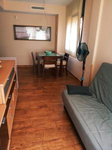 een woonkamer met een bank en een tafel bij Apartamento con Piscina in Llança