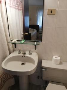 uma casa de banho com um lavatório, um WC e um espelho. em Hotel Cantamar em Viña del Mar