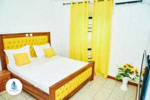 1 dormitorio con 1 cama grande y cortinas amarillas en Atlantic View Apartments, en Limbe 63 fotos más