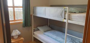 1 dormitorio con 2 literas y ventana en Vorsabær 2 Holiday Home en Fjall