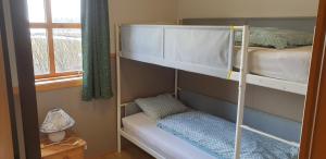 a bedroom with two bunk beds and a window at Vorsabær 2 Holiday Home in Fjall