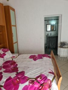 a bedroom with a bed with pink flowers on it at maisonnette à la campagne in San-Gavino-di-Carbini
