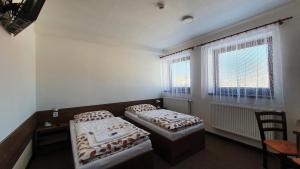 1 dormitorio con 2 camas y ventana en Motorest U Kola, en Prostějov
