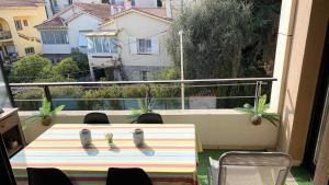 einen Tisch und Stühle auf einem Balkon mit Aussicht in der Unterkunft T2 proche de la gare, à 10 minutes à pieds de la Croisette, piscine & parking dans résidence de haut standing in Cannes