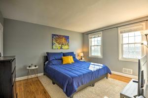 a bedroom with a bed with blue sheets and yellow pillows at Welcoming Baltimore Metro Gem about 9 Mi to Dtwn! in Towson