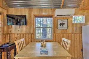 uma sala de jantar com uma mesa de madeira e um frigorífico em Lakefront Cabin with 2 Lofts, Boats on 4 Acres em Winnsboro