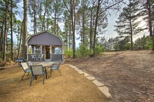 un cenador con mesa y sillas en el bosque en Lakefront Cabin with 2 Lofts, Boats on 4 Acres, en Winnsboro
