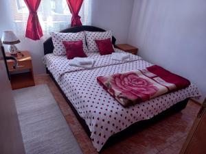 a bedroom with a bed with a polka dot bedspread at Apartmani Sobe Sljivancanin in Žabljak