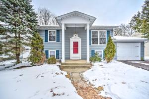 a blue house with a red door in the snow at Updated Home in the Heart of Saratoga Springs in Saratoga Springs