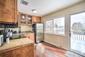 a kitchen with wooden cabinets and a large window at Updated Home in the Heart of Saratoga Springs in Saratoga Springs