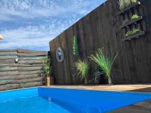 a backyard with a wooden fence and a blue swimming pool at Casa rural Laguna Herrera in Campo de Cuéllar