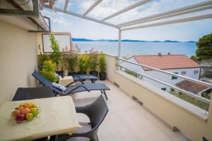 a balcony with tables and chairs and a view of the water at Beach Apartments Marijana in Vodice