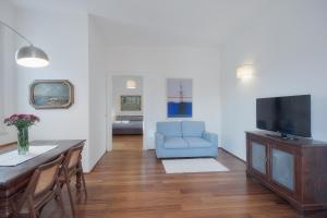 sala de estar con sofá azul y TV en Right House Splendid Harbour View, en Cagliari