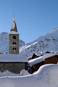 una iglesia con un campanario en la nieve en L'Annexe, en Val dʼIsère