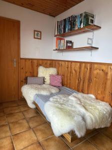 a bedroom with two beds with faux fur at Gemütliche Wohnung mit Traumaussicht! in Albinen