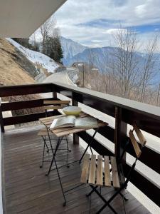 a table and chairs on a balcony with a view of a mountain at Gemütliche Wohnung mit Traumaussicht! in Albinen