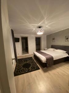 a bedroom with a large bed and a rug at Garsonierele Scandinav in Predeal