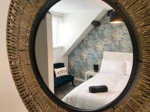 a bedroom with a bed and a mirror at The Beach Hut - 1 Bedroom Apartment Near the Beach in Bournemouth