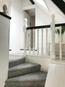 a staircase with white railings in a home at The Beach Hut - 1 Bedroom Apartment Near the Beach in Bournemouth