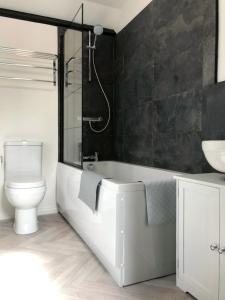 La salle de bains est pourvue d'une baignoire, de toilettes et d'un lavabo. dans l'établissement The Beach Hut - 1 Bedroom Apartment Near the Beach, à Bournemouth