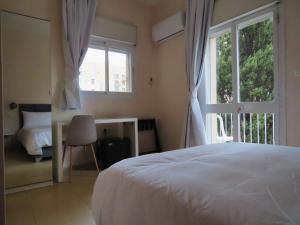 ein Schlafzimmer mit einem weißen Bett und einem Fenster in der Unterkunft B12 Inn in Jerusalem