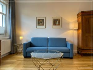 a living room with a blue couch and a table at Saar-Apartments in Merzig