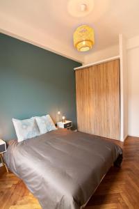 ein Schlafzimmer mit einem großen Bett und einer grünen Wand in der Unterkunft Théâtre de la Cité in Nizza
