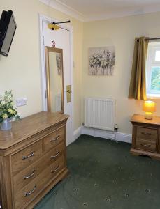 a room with a wooden dresser and a mirror at Bryn Noddfa in Morfa Nefyn