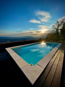 a swimming pool with a sunset in the background at Villa la Moresca Relais de Charme BeB Adults only in Montecatini Terme