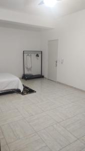a white room with a bed and a tiled floor at Catumbi Studio 8 in Sao Paulo