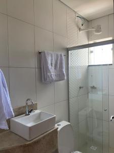 La salle de bains est pourvue d'un lavabo, de toilettes et d'une douche. dans l'établissement Honório pousada - Tucano BA, à Tucano