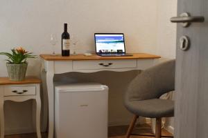a desk with a bottle of wine and a laptop on it at Old stone house in historical area in Split