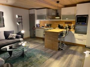 a kitchen and living room with a couch and a table at Mon nid montagnard au soleil in Les Deux Alpes