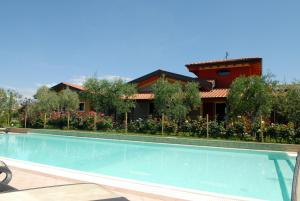 a swimming pool in front of a house at Locanda dei Rii in Manerba del Garda