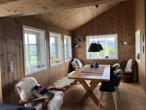 - une salle à manger avec une table, des chaises et des fenêtres dans l'établissement Sinnes near Kjerag, à Tjørhom