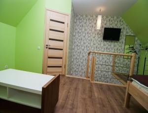 a bedroom with a bed and a tv on a wall at VitaVila in Palanga