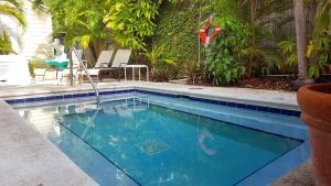 a swimming pool in a yard with a pool at Authors Key West Guesthouse in Key West