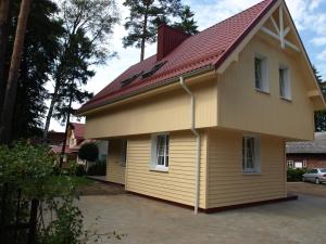 a yellow house with a red roof at VitaVila in Palanga