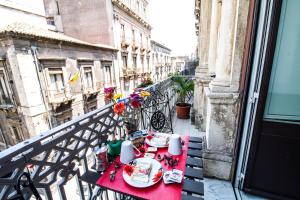 einen Tisch auf dem Balkon eines Gebäudes mit Essen drauf in der Unterkunft Le Muse Catanesi in Catania