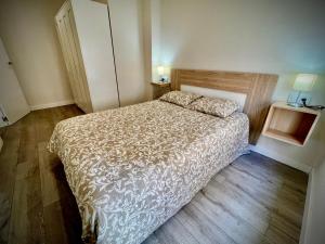 a small bedroom with a bed and a wooden floor at Apartamento Jazmín in Córdoba