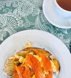 a plate with a sandwich on a table with a cup of coffee at Bryn Noddfa in Morfa Nefyn