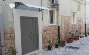 a door in a white building with potted plants at Darsena Apartments1 in Molfetta