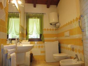 ein Badezimmer mit Waschbecken und Toilette und Waschbecken in der Unterkunft Mi casa el mar! Grazioso attico 400 mt alla spiaggia e al centro in Castelsardo + 25 Fotos