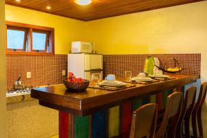 uma cozinha com um balcão com uma mesa com uma tigela de frutas em Atmosphera Pousada em Arraial d'Ajuda