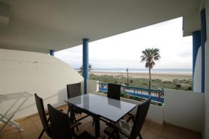 - une salle à manger avec une table et des chaises ainsi qu'une plage dans l'établissement Livingtarifa Apartamento Agaporni, à Tarifa