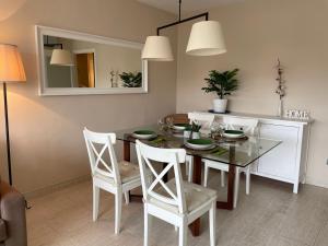 una sala da pranzo con tavolo, sedie e specchio di A 600 metros de la playa, ideal para familias a S'Agaró